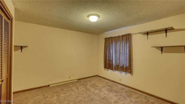 interior space with light carpet, a closet, and a baseboard heating unit