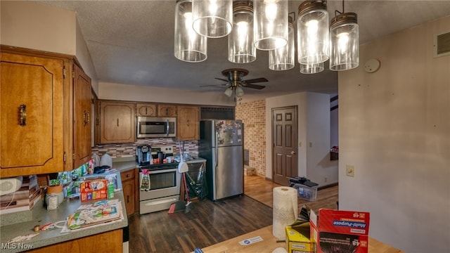 kitchen featuring appliances with stainless steel finishes, dark hardwood / wood-style floors, and ceiling fan