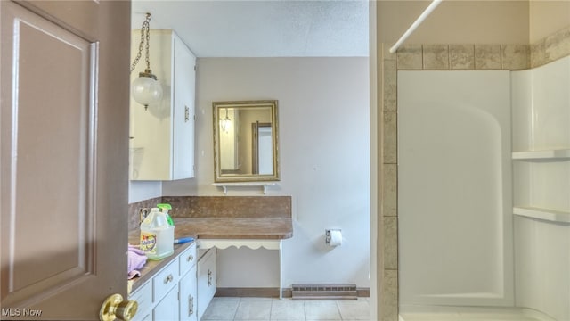 bathroom featuring tile patterned flooring, vanity, and walk in shower