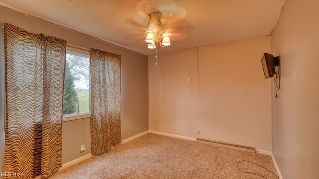 empty room with a textured ceiling, carpet floors, and baseboard heating