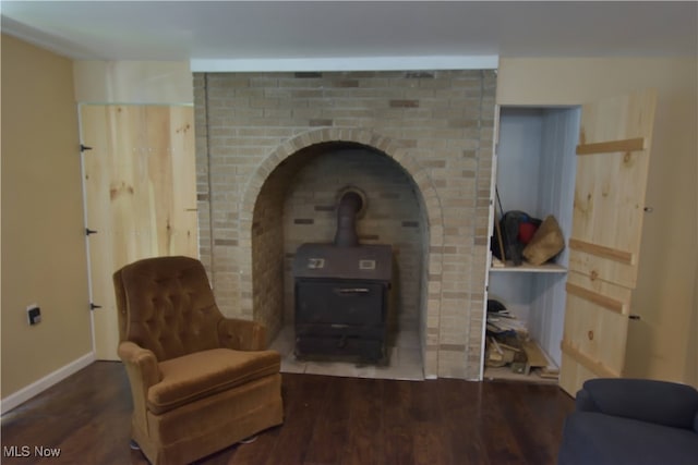 sitting room featuring a wood stove and hardwood / wood-style floors