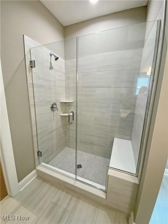 bathroom featuring a shower with shower door