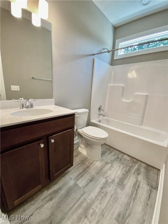 full bathroom featuring wood-type flooring, vanity, toilet, and shower / washtub combination