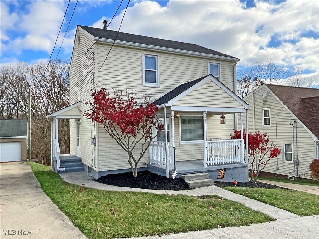 view of front of home with covered porch and an outbuilding