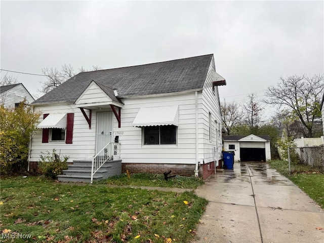 view of front of home featuring an outdoor structure, a front yard, and a garage