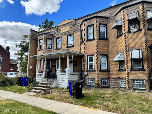 view of property featuring brick siding and covered porch