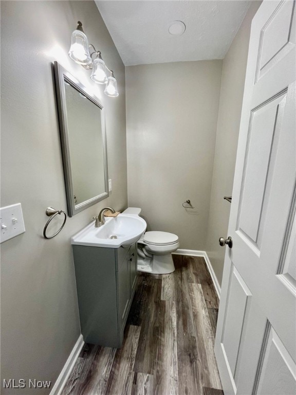 bathroom featuring vanity, hardwood / wood-style flooring, and toilet