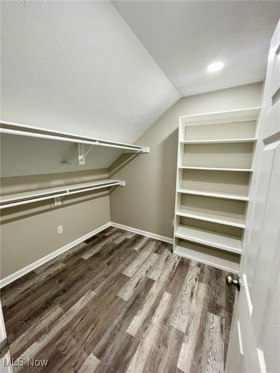 spacious closet featuring wood-type flooring and lofted ceiling