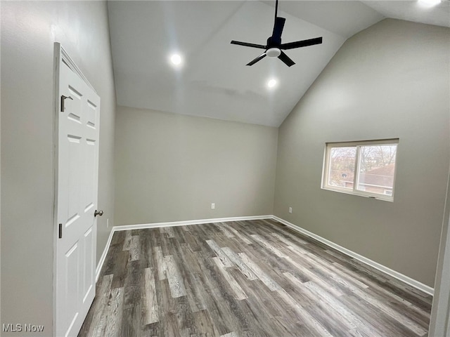 spare room featuring wood-type flooring, high vaulted ceiling, and ceiling fan