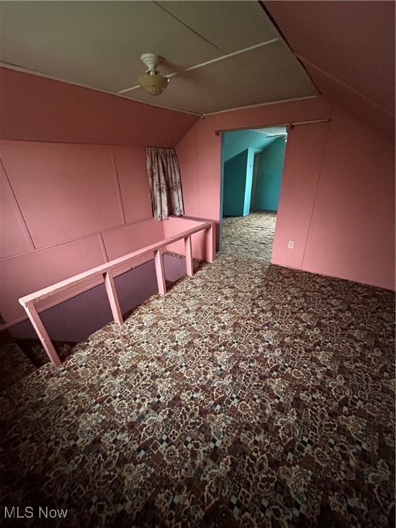 hallway with carpet and lofted ceiling