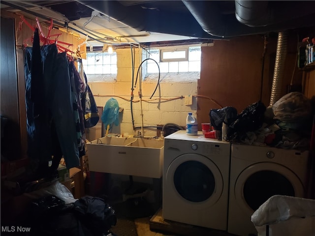 clothes washing area with independent washer and dryer and sink