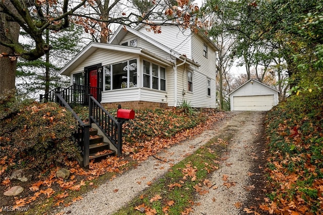 view of front of property featuring a sunroom, a garage, and an outdoor structure