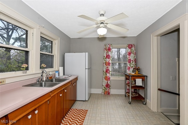 kitchen featuring white refrigerator, ceiling fan, and sink