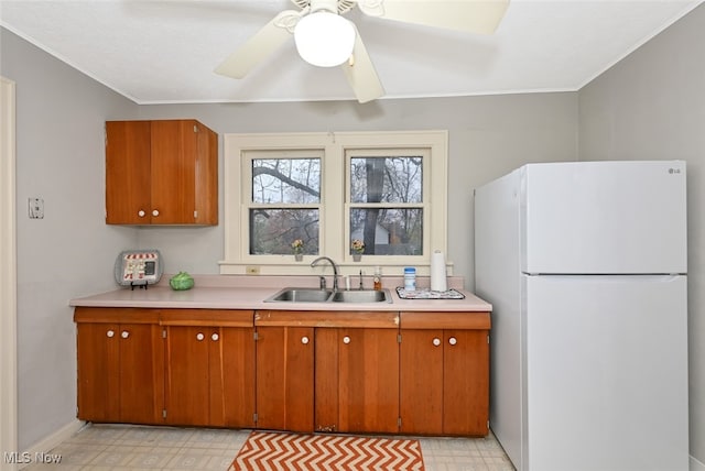 kitchen with ceiling fan, white fridge, and sink