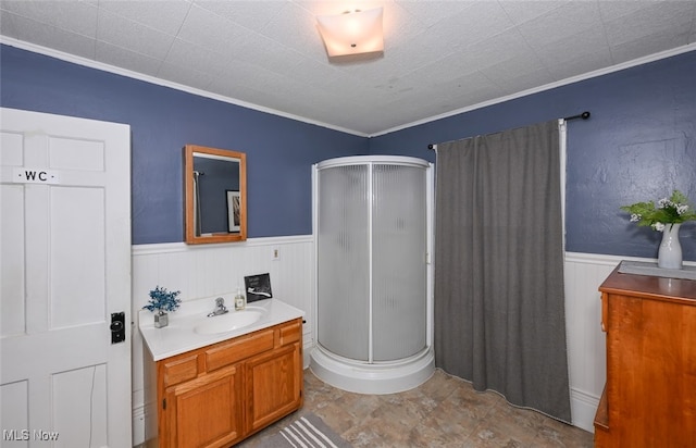 bathroom with vanity, an enclosed shower, and ornamental molding