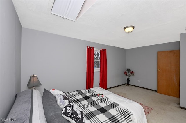 bedroom featuring light colored carpet and a textured ceiling