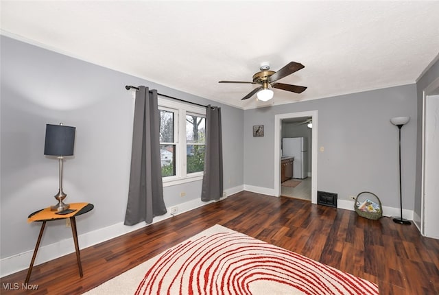 bedroom with ceiling fan, ensuite bathroom, white fridge, and dark wood-type flooring