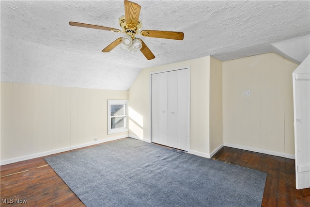 bonus room with a textured ceiling, ceiling fan, dark hardwood / wood-style flooring, and lofted ceiling