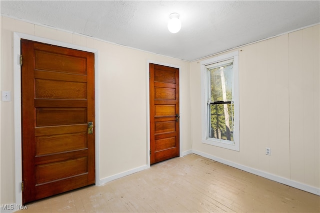 unfurnished bedroom featuring a textured ceiling and light wood-type flooring