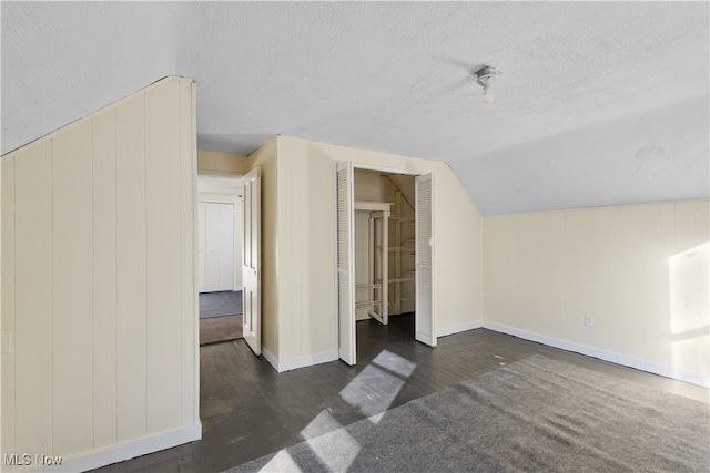 bonus room featuring a textured ceiling, dark hardwood / wood-style floors, and lofted ceiling