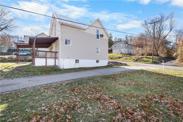 view of side of home with a lawn and covered porch