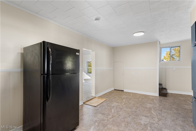 kitchen featuring black refrigerator and ornamental molding