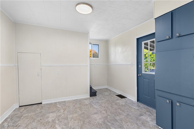 entryway with ornamental molding and a wealth of natural light