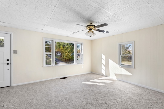 interior space with light colored carpet, a drop ceiling, and ceiling fan