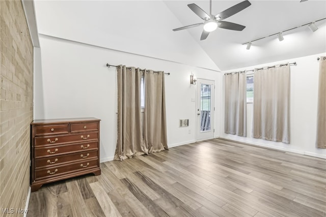 unfurnished room with rail lighting, high vaulted ceiling, light hardwood / wood-style flooring, and ceiling fan