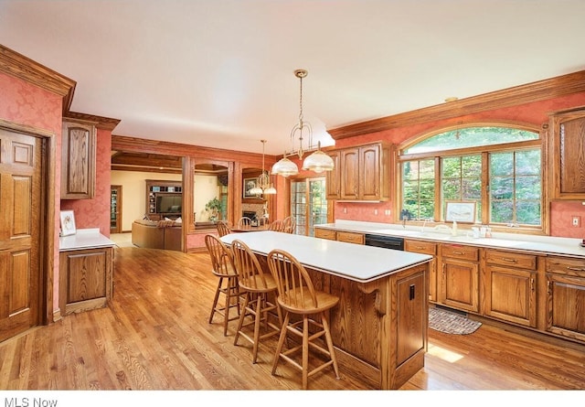 kitchen featuring pendant lighting, a center island, light hardwood / wood-style floors, a breakfast bar area, and a chandelier