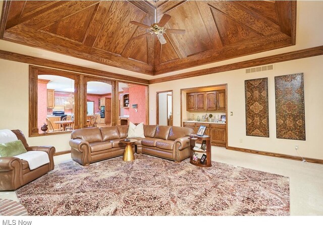 carpeted living room with ceiling fan and wood ceiling