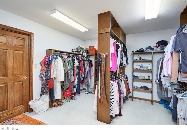 walk in closet featuring light carpet