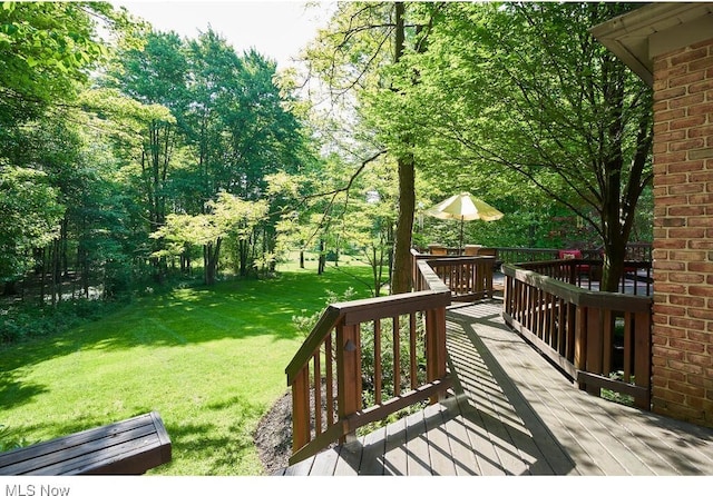 wooden terrace featuring a yard