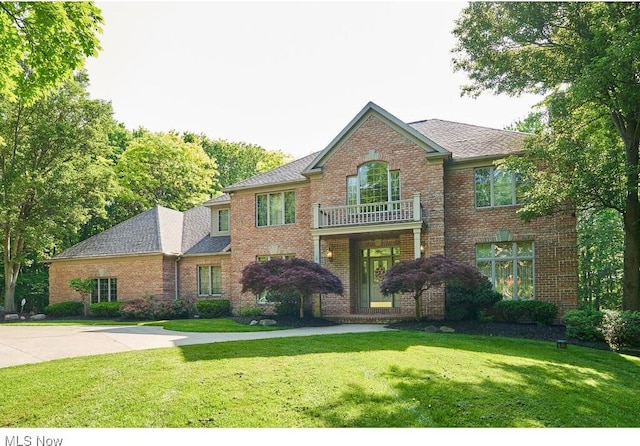 view of front facade featuring a balcony and a front lawn