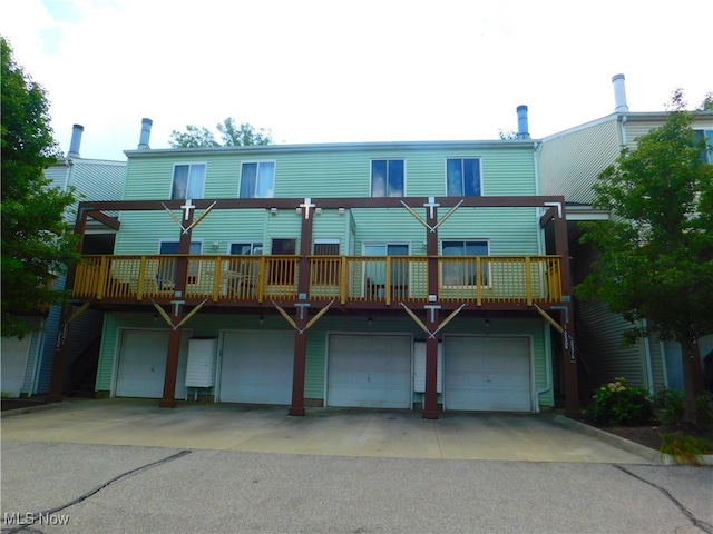 rear view of house with a wooden deck and a garage