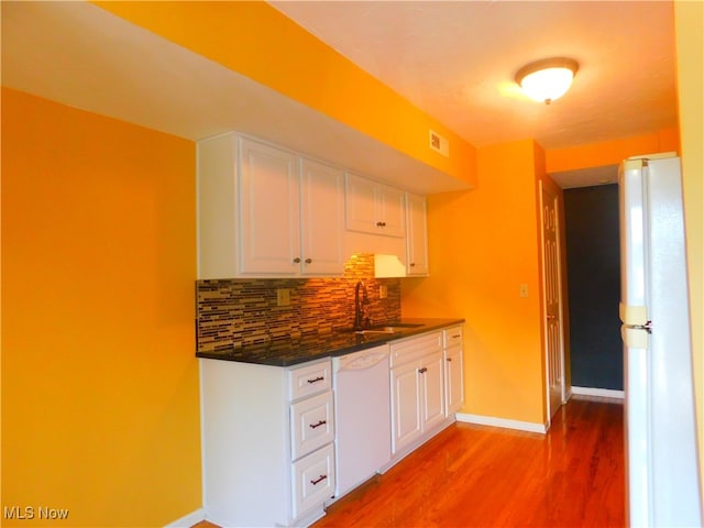 kitchen with white cabinetry, wood-type flooring, white appliances, and sink