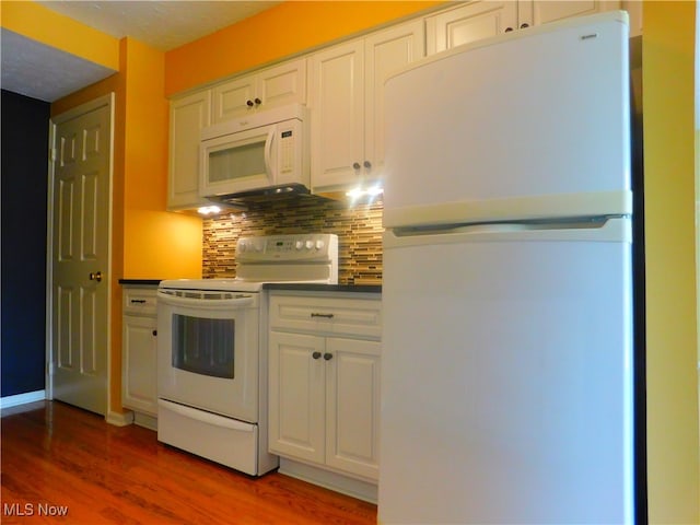 kitchen with white cabinets, dark hardwood / wood-style flooring, white appliances, and backsplash