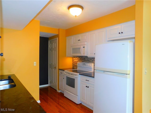 kitchen with dark hardwood / wood-style flooring, white cabinets, and white appliances