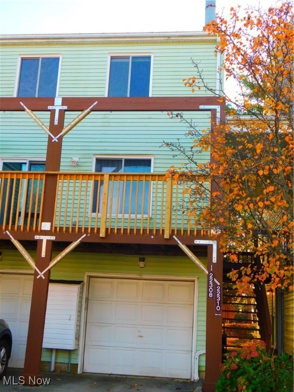 back of property with a garage and a balcony