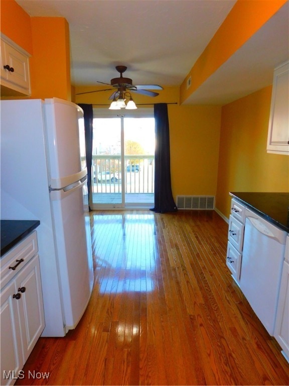 kitchen with ceiling fan, white cabinets, wood-type flooring, and white appliances