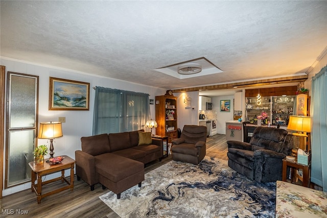 living room featuring hardwood / wood-style flooring, ornamental molding, and a textured ceiling