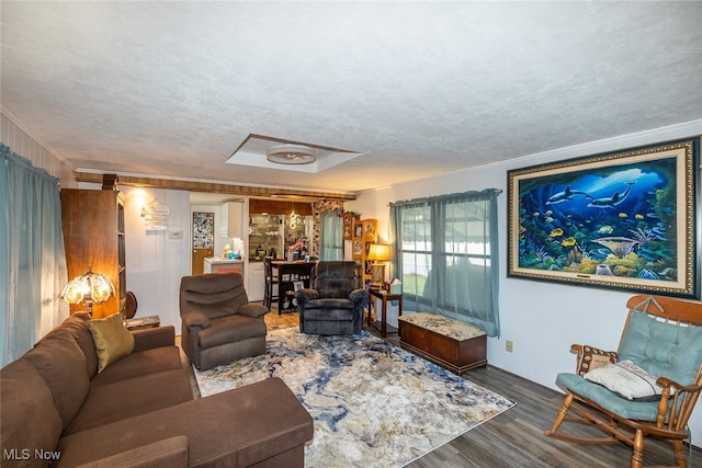 living room featuring a textured ceiling, dark hardwood / wood-style flooring, and crown molding