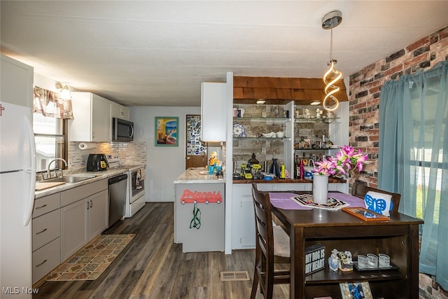 kitchen featuring sink, dark hardwood / wood-style floors, decorative light fixtures, white cabinetry, and stainless steel appliances