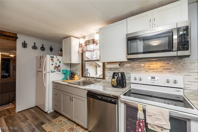 kitchen featuring sink, decorative backsplash, appliances with stainless steel finishes, dark hardwood / wood-style flooring, and white cabinetry