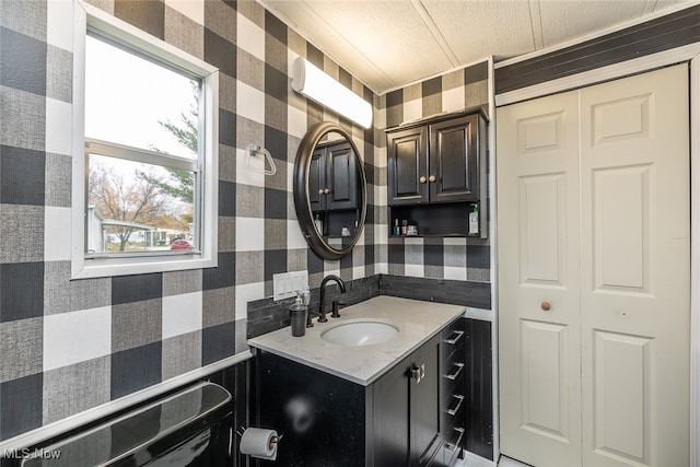 bathroom with vanity, a textured ceiling, and backsplash