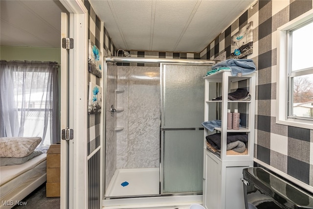 bathroom featuring a textured ceiling and a shower with door