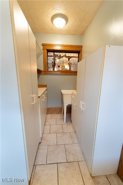 interior space with light tile patterned floors and a textured ceiling