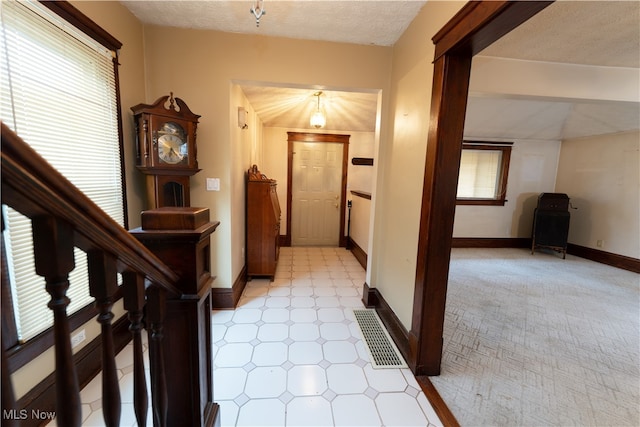 entrance foyer featuring visible vents, baseboards, and a textured ceiling