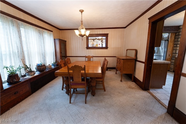 dining area featuring a healthy amount of sunlight, crown molding, and a chandelier