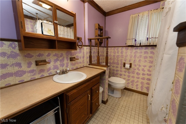 full bathroom featuring a wainscoted wall, toilet, a textured ceiling, crown molding, and vanity